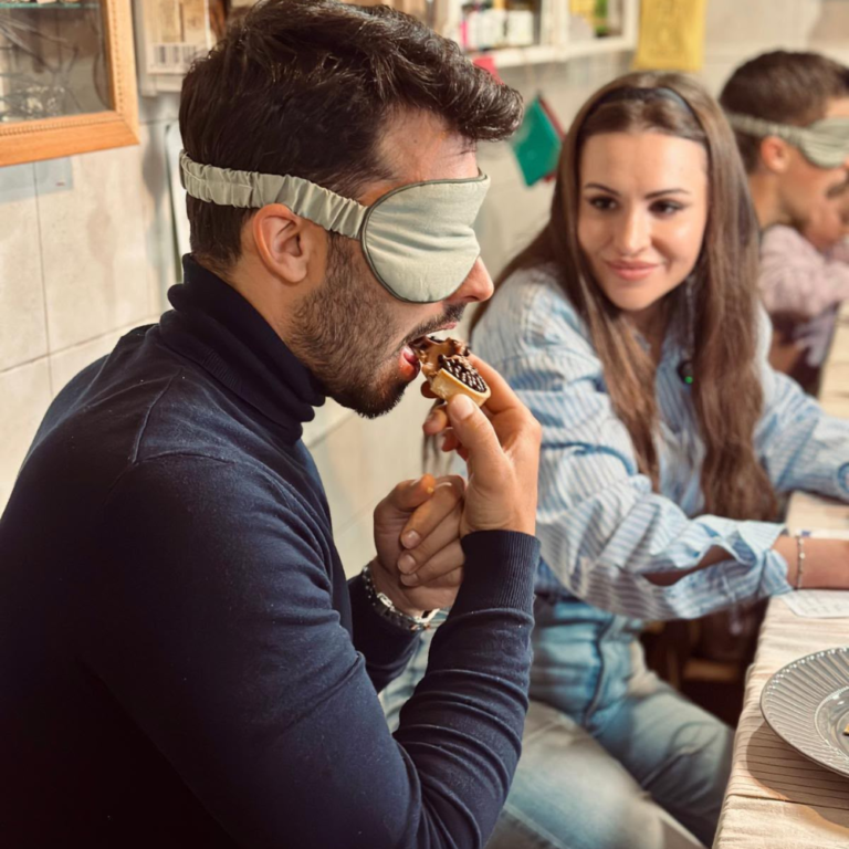 Hombre con antifaz probando un dulce durante la cata a ciegas Sabores que no se ven